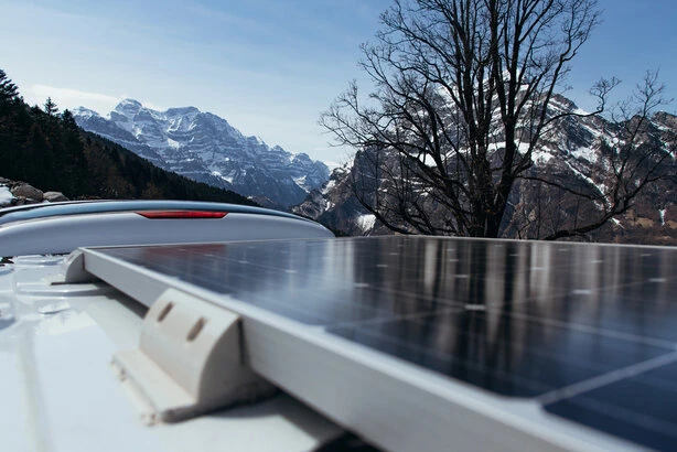 Wohnmobil mit Solarpanelen auf dem Dach auf einem Stellplatz